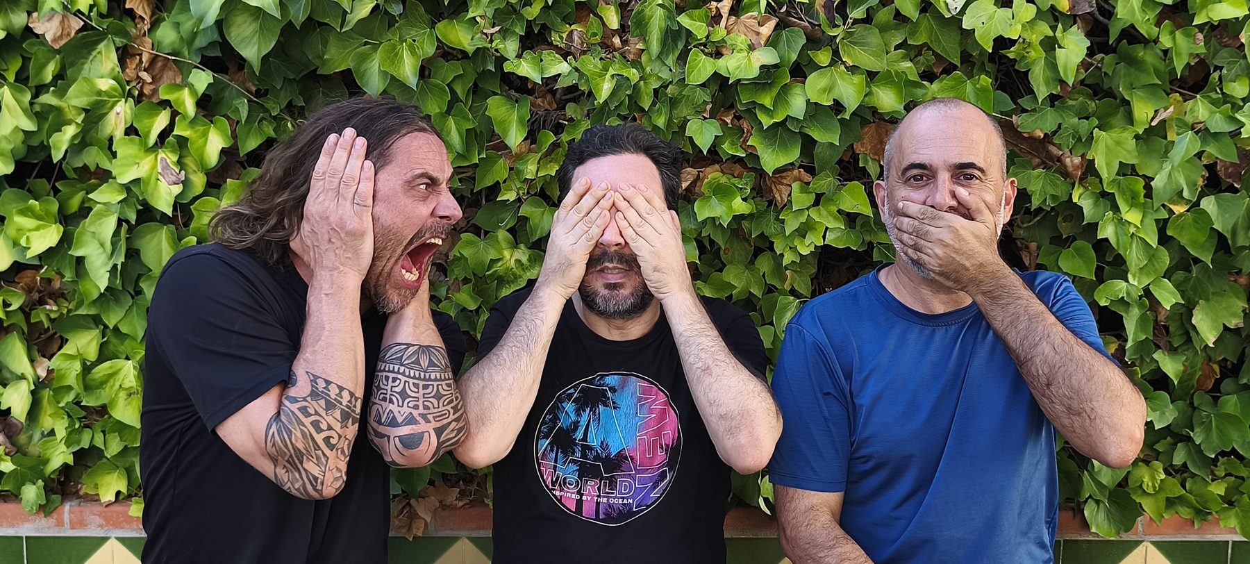 Los tres músicos de MEHARY imitando la pose de los tres monos sabios: uno tapándose los oídos, otro los ojos y otro la boca.